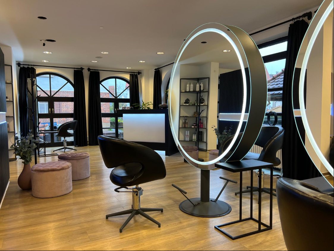 Moderner Friseursalon mit beleuchteten runden Spiegeln